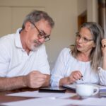 Älteres Paar bespricht Unterlagen am Tisch